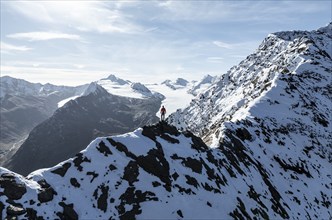 Mountaineer standing on the snow-covered Ramoljoch under a clear sky in the Alps, behind glacier