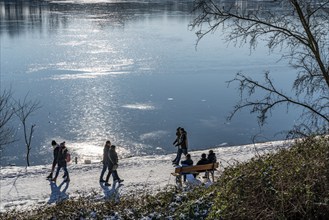 Winter in the Ruhr area, Lake Baldeney, snow-covered, partly frozen lake, walkers on the lakeside