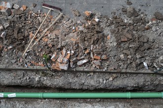 Newly laid green sewage pipe, trench, excavation, broom and pickaxe, Stuttgart, Baden-Württemberg