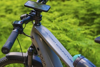 Close-up of an e-bike with the lettering 'Black Forest Manufacture' in green surroundings,