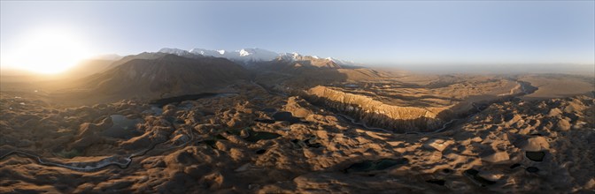 Panorama, White glaciated and snow-covered mountain peak Pik Lenin at sunrise, hilly landscape with