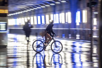 Street at the central station, cyclist, rainy weather, city centre, in the evening, Essen, North