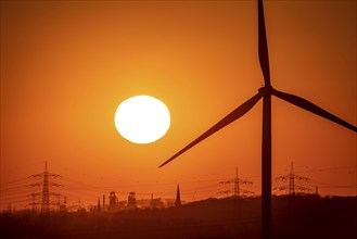 Wind turbine of the Emschergenossenschaft, view to the west, in Essen, sunset, behind the blast