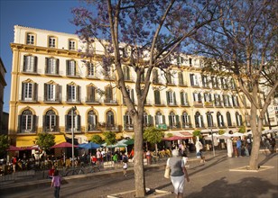 People sitting outside popular cafes on a sunny afternoon in Plaza de la Merced, Malaga, Spain,