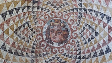 Head of Dionysus with fruit and ivy in his hair, finely worked antique mosaic with a centred