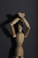 Wooden mannequin stands with raised hands on gray background. protest, attention concept. copy