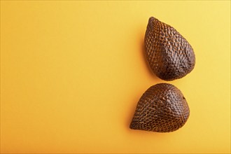 Salak or snake fruit on orange pastel background. Top view, flat lay, copy space. Tropical, healthy