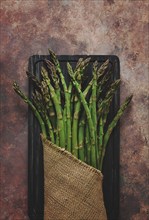 Bouquet of fresh asparagus, on an abstract background, top view, rustic, no people