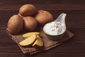 Potato starch, on a wooden table, close-up, rustic style, no people, potatoes, ceramic spoon,