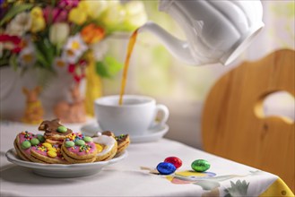 Breakfast scene with Easter biscuits and coffee being poured into a cup, Easter