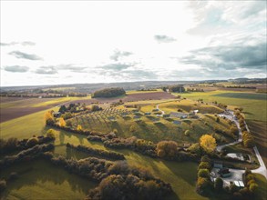 Aerial view of an extensive rural autumn landscape with fields and small buildings, solar park.