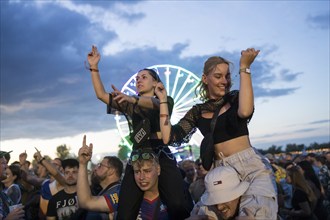 Festival visitors celebrate on shoulders during Ski Aggu's performance in front of the Ferris wheel