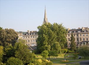 Parade Gardens public park in city centre of Bath, Somerset, England with church spire in