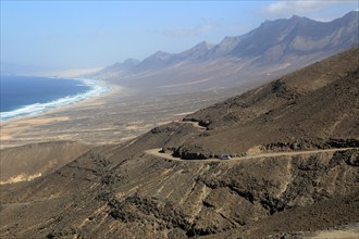 Car driving on unsurfaced road, Atlantic Ocean coast, Jandia peninsula, Fuerteventura, Canary