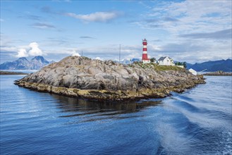 Lighthouse on island Skrova, rocky small island, view towards Lofoten islands, mountain Vågekallen