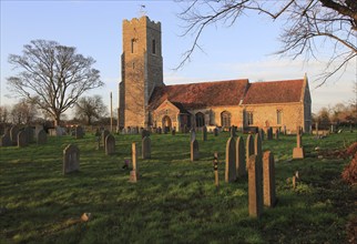 Late afternoon winter golden light falls on Saint John the Baptist church, Snape, Suffolk, England,