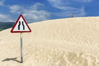 Moving dune with traffic sign, caution narrowed lane, narrowing of lane, dune, coastline near