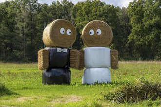 Straw bale dolls, figures, as wedding couple, in front of a house near Arcen, Netherlands,