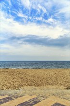 View from the empty sandy beach to the sea and cloudy sky, sunny autumn weather, full format, Wyk