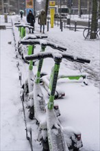 Winter in the city, snow-covered e-scooters from On Lime Uber, Gallusanlage, Frankfurt am Main,