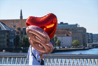 Woman with gas-filled balloons, congratulating on the way to a party, Copenhagen, Denmark, Europe