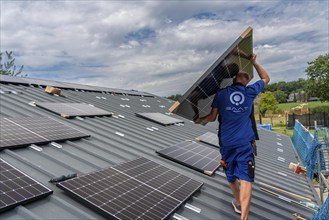 Installation of solar modules on the roof of a barn on a farm, over 240 photovoltaic modules are