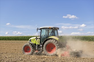 Symbolic image, global warming, dry soil, dust, farmer tilling a field, tractor, ploughing, clouds,