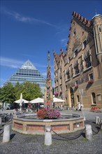 The fish box fountain on the market square, on the right the town hall opposite the central