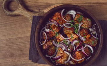 Fried meat, pork kebab, ketsi in a clay pan, with red onions and herbs, homemade, no people