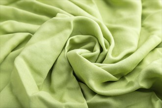 Fragment of green linen tissue. Side view, natural textile background and texture. wave concept,