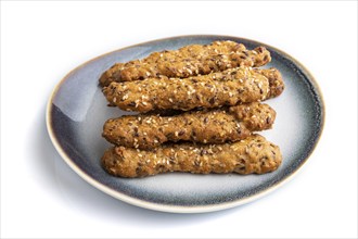 Crumble cookies with seasme and almonds on ceramic plate isolated on white background. side view,