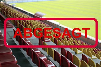 Symbolic image: Red sign with the message (event) cancelled with an empty stadium in the background