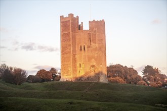 Late afternoon winter sunshine shining on walls of Orford Castle, Orford, Suffolk, England, United