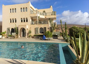 Woman swimming infinity pool by Hotel auberge Dar Najmat, Mirleft, Morocco, north Africa, Africa