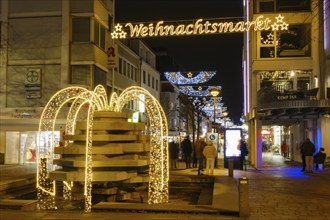 Illuminated fountain and Christmas decoration above the pedestrian zone, night shot, Paderborn,