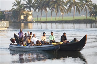 Indian men travelling on a motorboat, canal system of the backwaters, Kerala, India, Asia