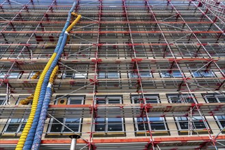 Large construction site, scaffolded shell of an office building complex, air hoses for building