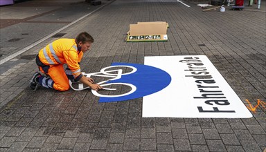 Application of road markings for a cycle lane, Rüttenscheider Straße in Essen, in the shopping and