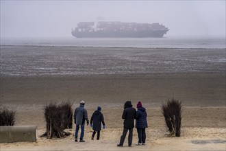 Thick fog in winter, hanging over the mouth of the Elbe into the North Sea, container ship NYK