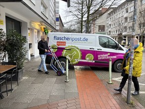 Delivery vehicle of the delivery service Flaschenpost.de parks on a pavement during delivery,