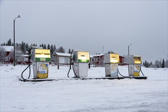 Illuminated petrol pumps at the only petrol station in Raattama, Lapland, Finland, Europe