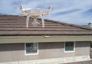 Quadcopter UAV drone flying A residential roof inspection