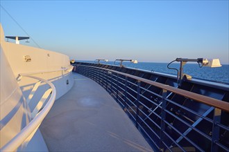 Deck of a cruise ship with clear blue sky and blue railing, Mein Schiff 6, North Sea, Denmark,