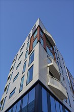 Ec of a modern building with large windows and balconies against a clear blue sky, Sandnes, Fylke