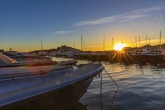 Luxury yachts under a low sun in the harbour of Eivissa, Ibiza Town, Ibiza, Balearic Islands,