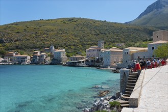 Coastal village with clear blue water and buildings on a sunny day, Limeni, Areopoli, Laconia,