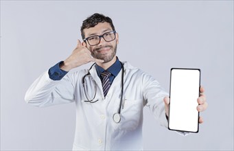 Handsome doctor showing cellphone screen gesturing call me. Happy doctor showing white screen of