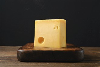 Block of Swiss cheese on cutting board