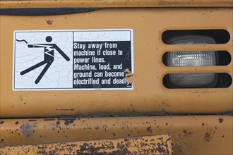 Pictogram and written danger warning sticker on heavy duty backhoe excavator, Quebec, Canada, North