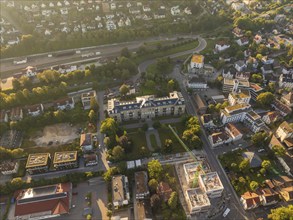 Aerial view of a city with a large building, a construction site and a railway line in the